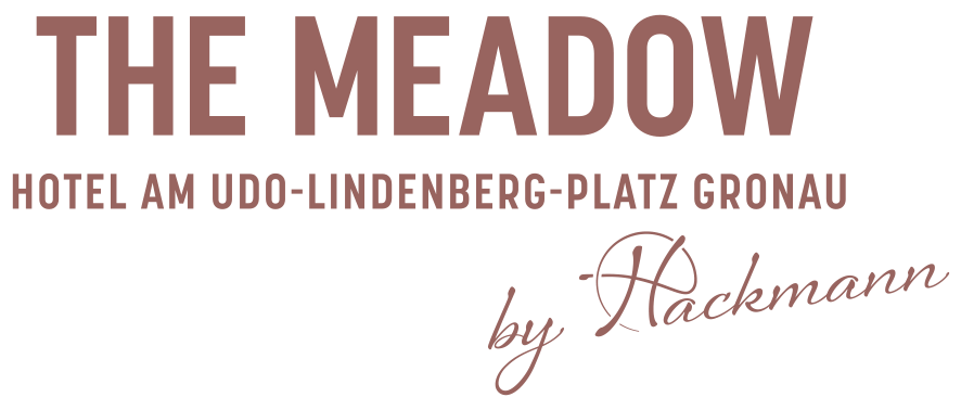 Logo The MEADOW Hotel Gronau by Hackmann Logo des The MEADOW Hotel Gronau by Hackmann mit stilisierter Wiesenlandschaft und Schriftzug.