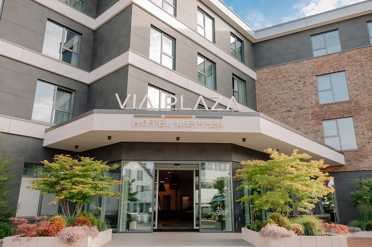 Haupteingang des VIA PLAZA Meppen mit Glasfront und begrüntem Eingangsbereich