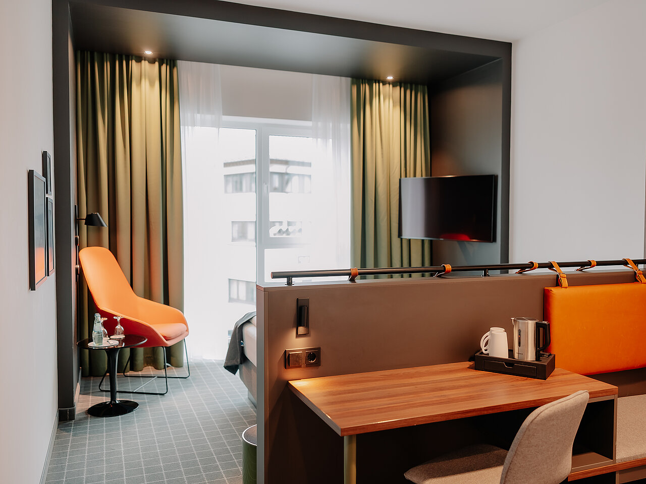 Doppelzimmer Superior im VIA PLAZA Meppen mit Schreibtisch, Lounge-Sessel und Stadtblick