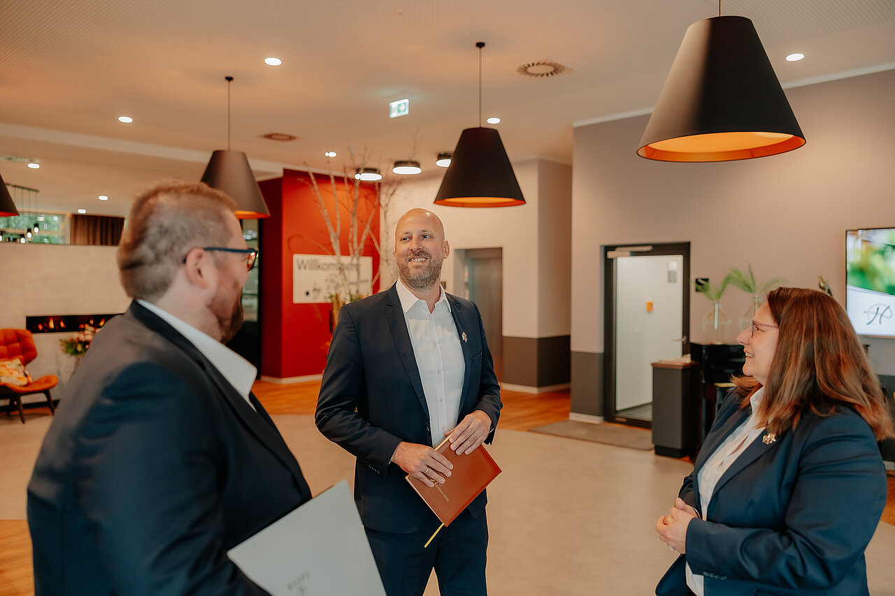 Drei Hotelmitarbeiter im Gespräch in der Lobby des VIA PLAZA Meppen