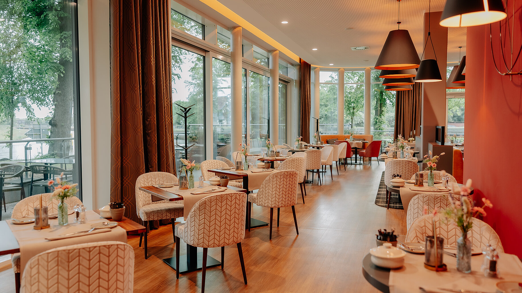 Restaurantbereich im VIA PLAZA Meppen mit großen Panoramafenstern und gedeckten Tischen