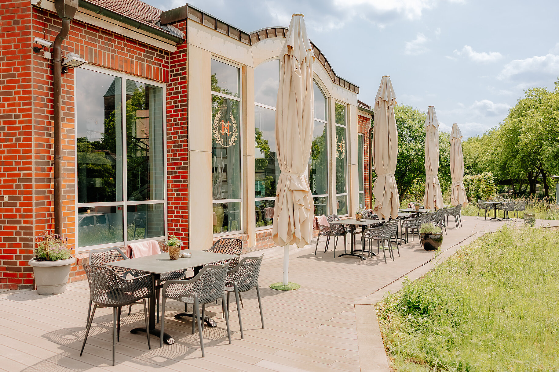 Sonnenterrasse mit Tischen, Stühlen und Sonnenschirmen am CASCADA Hotel Rheine