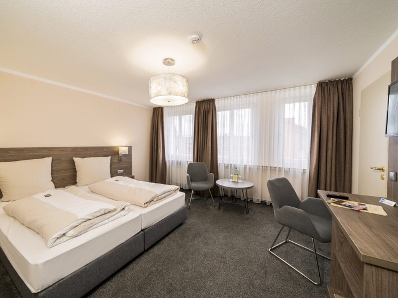 Helles Doppelzimmer mit Sitzbereich im Parkhotel Lingen