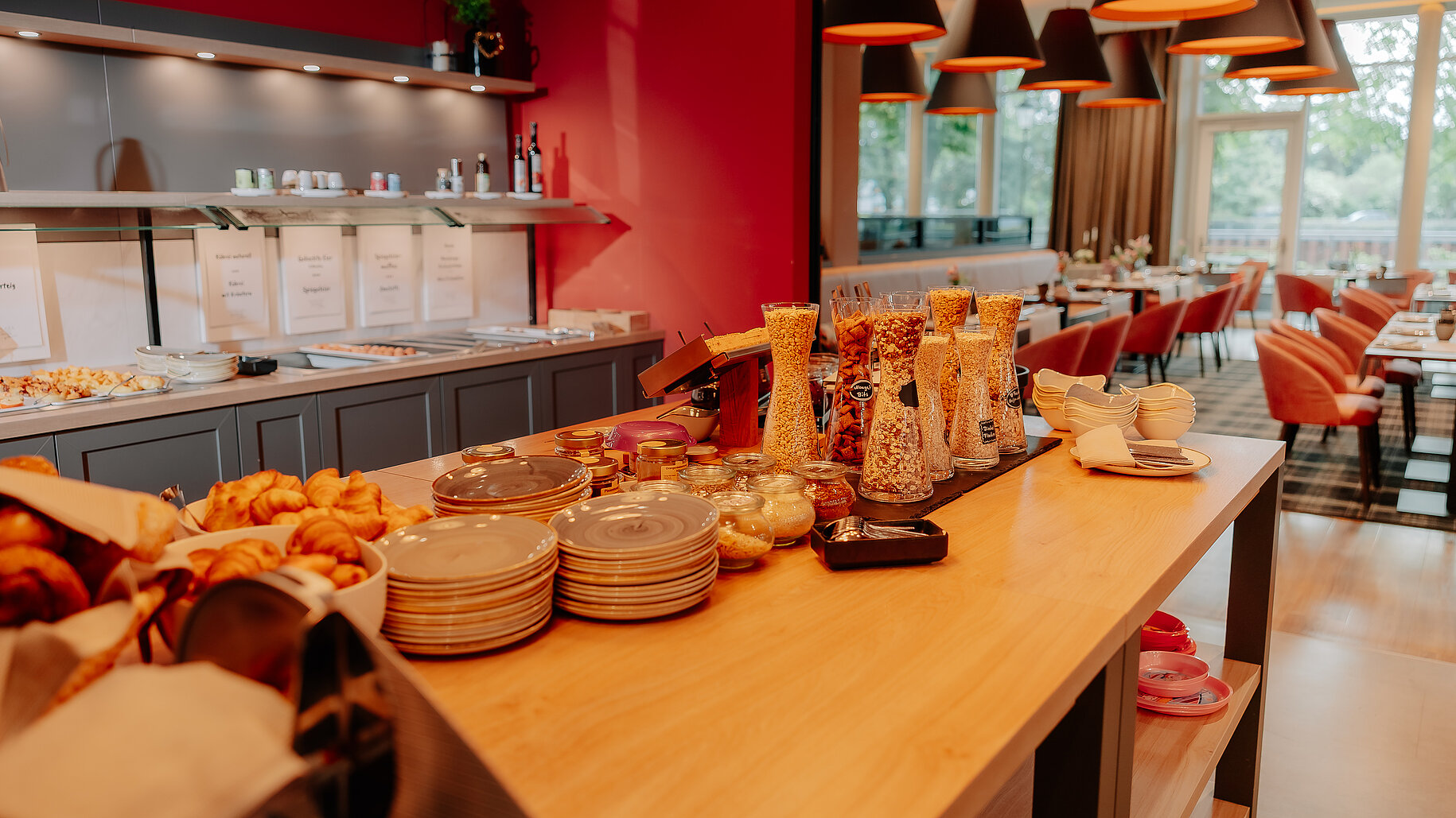 Frühstücksbuffet mit Müslibar, Croissants und warmen Speisen im modern gestalteten Restaurantbereich