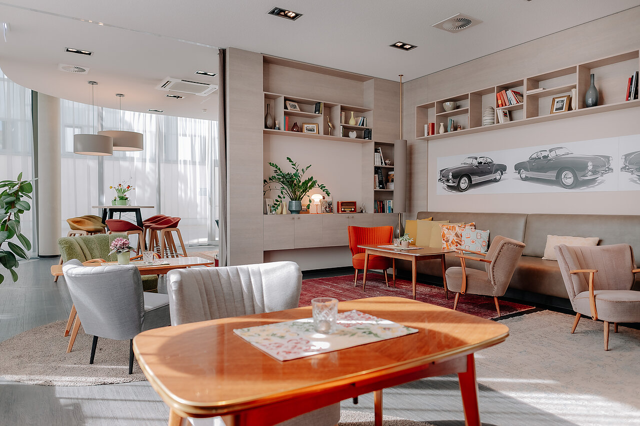 Living Room im CrossINN Osnabrück Heller Living Room im CrossINN Osnabrück mit Sesseln, Sofas und Motiven klassischer Automobile