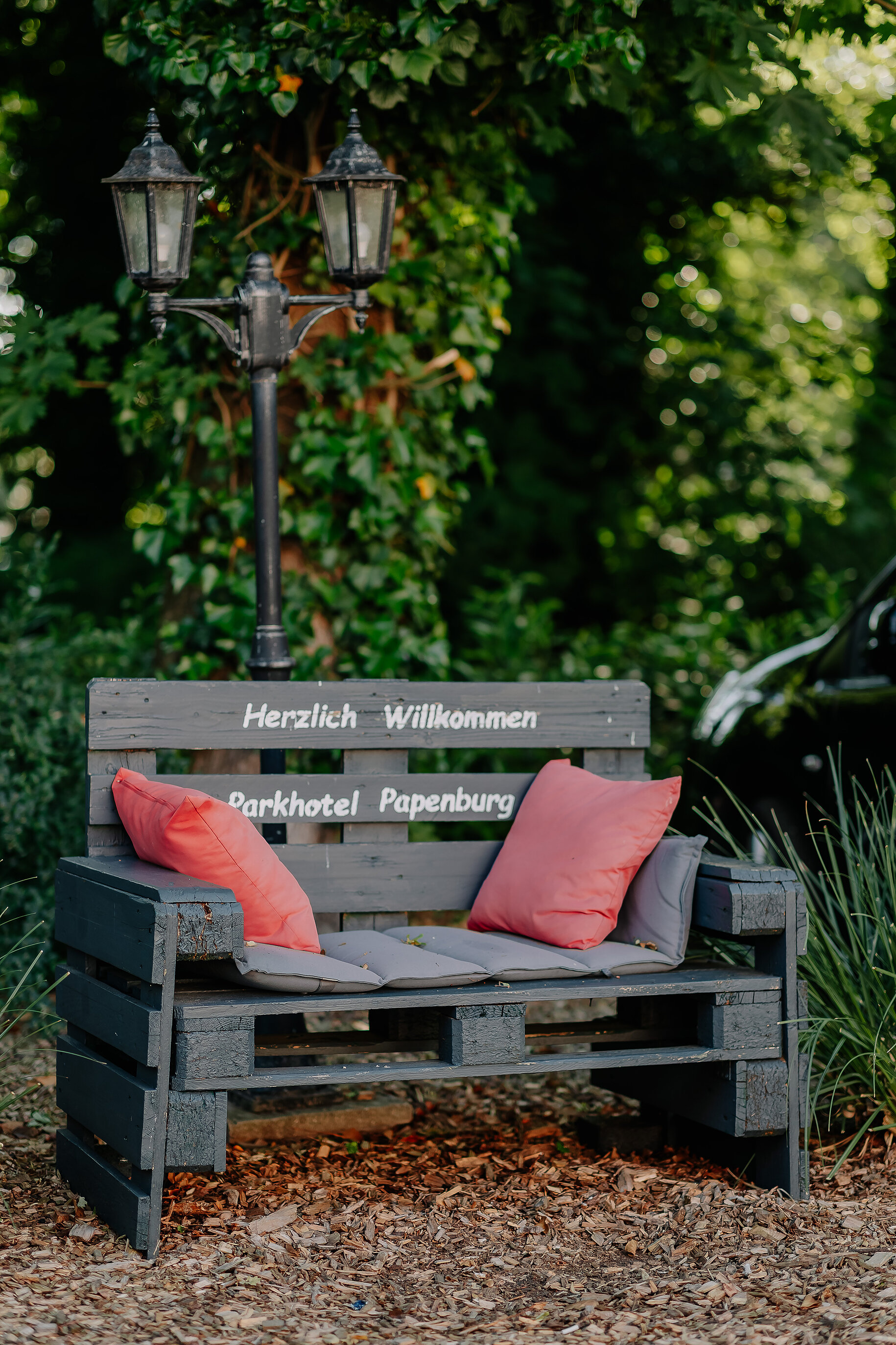 Sitzgruppe auf der Terrasse des Parkhotel Papenburg inmitten eines grünen Gartenbereichs.