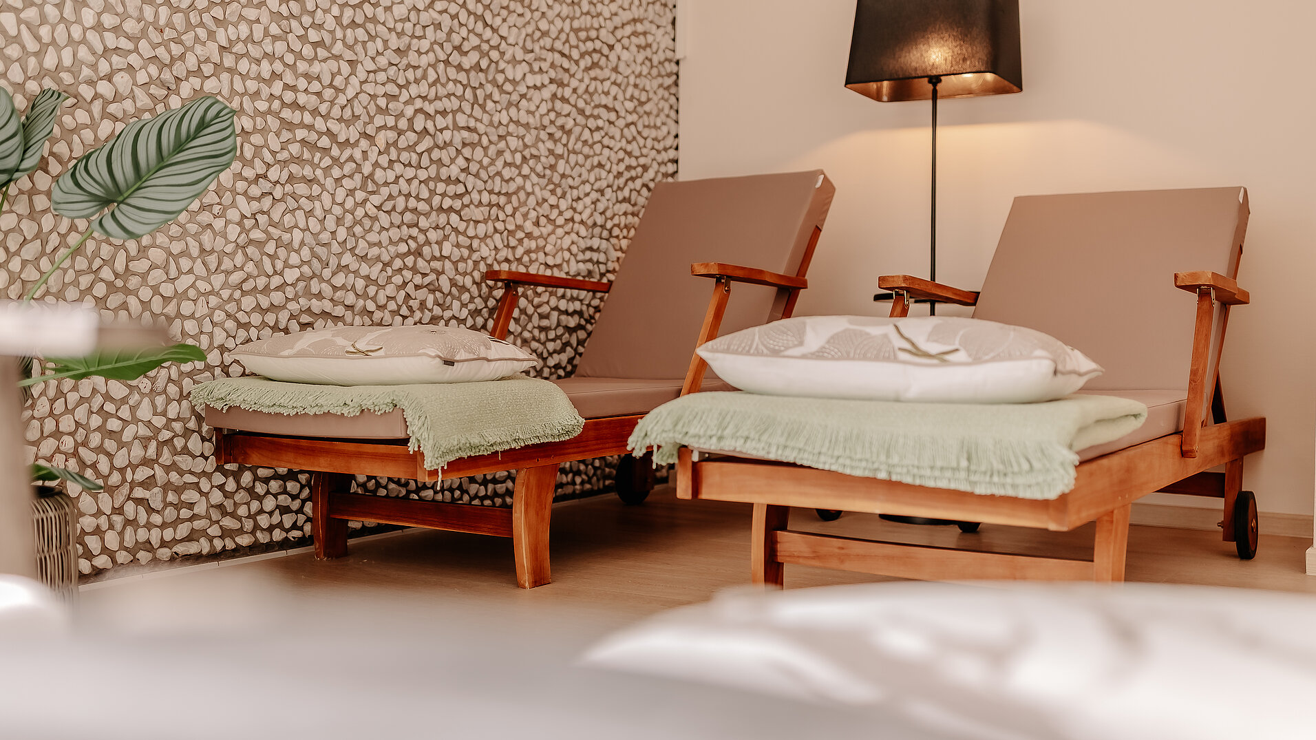 Zwei Liegen mit Kissen und Decken im Wellnessbereich des INSIDE Hotel Nordhorn