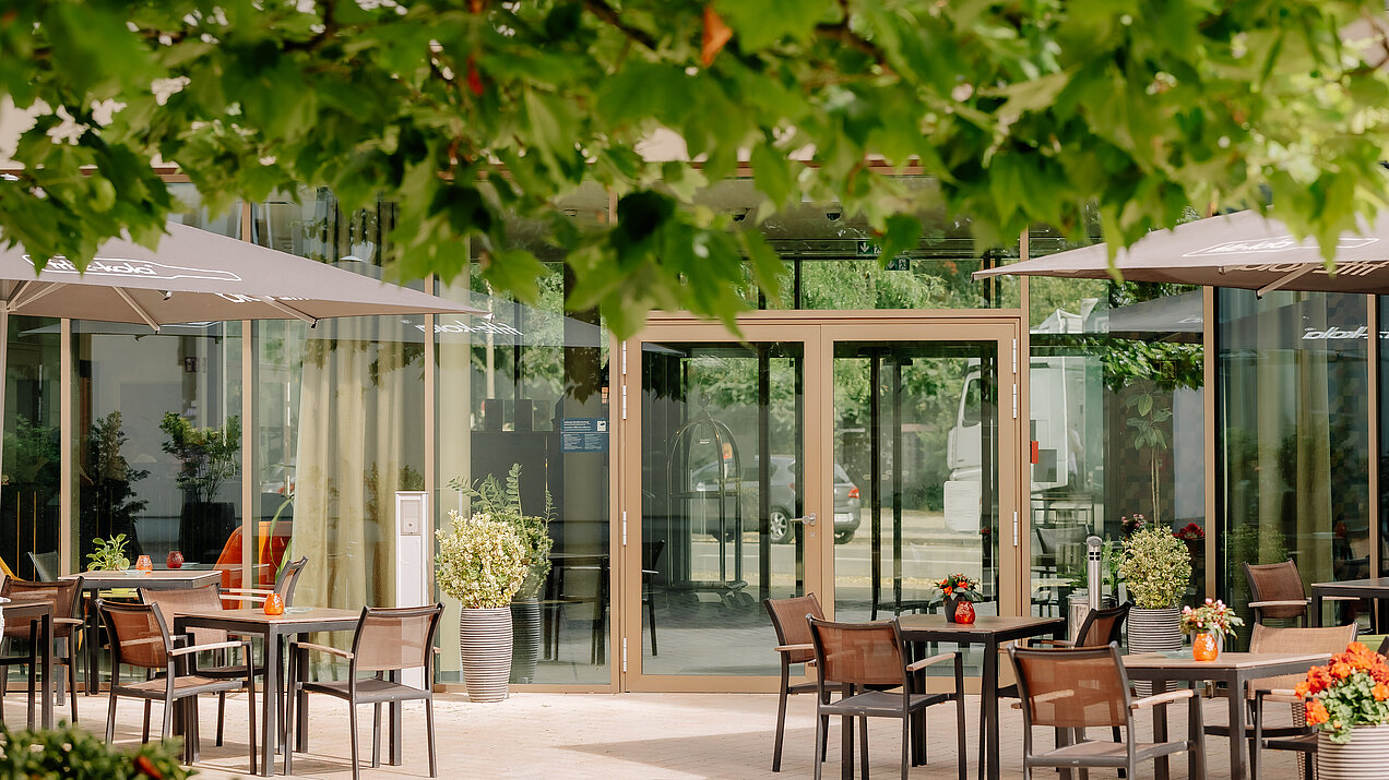 Terrasse am CrossINN Osnabrück Begrünte Terrasse mit Sitzplätzen vor dem Eingang des CrossINN Osnabrück