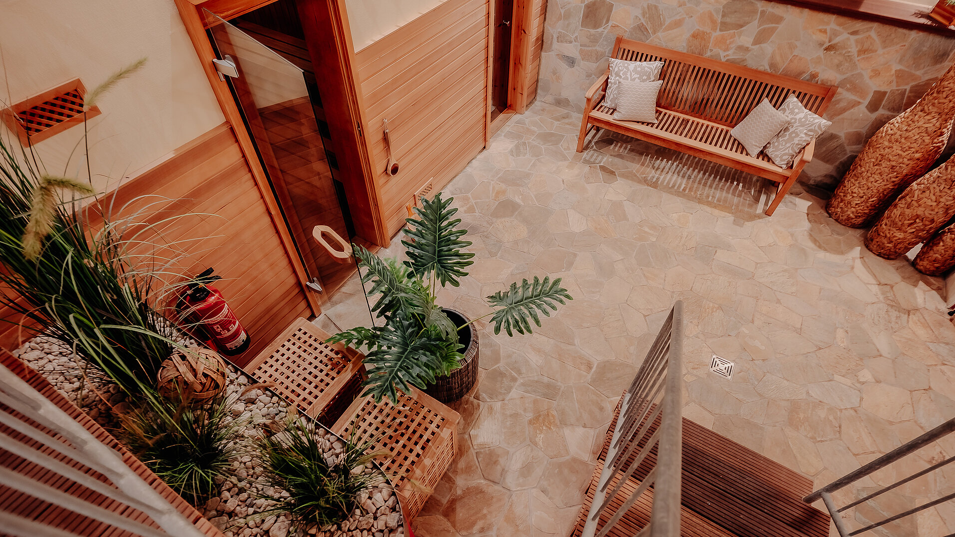  Blick von oben auf den Saunabereich im INSIDE Hotel Nordhorn mit Sitzbank und Pflanzen