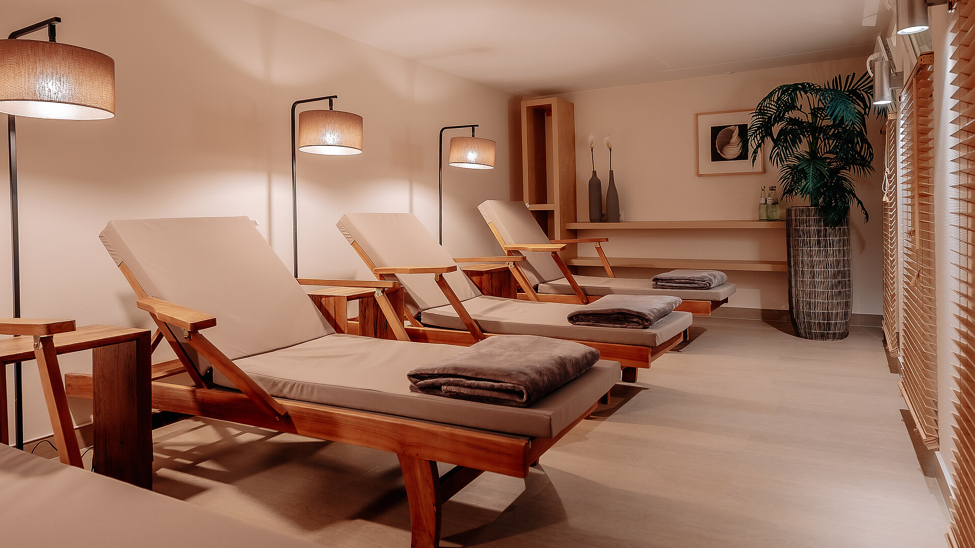 Wellnessraum mit mehreren Liegen und Stehlampen im INSIDE Hotel Nordhorn