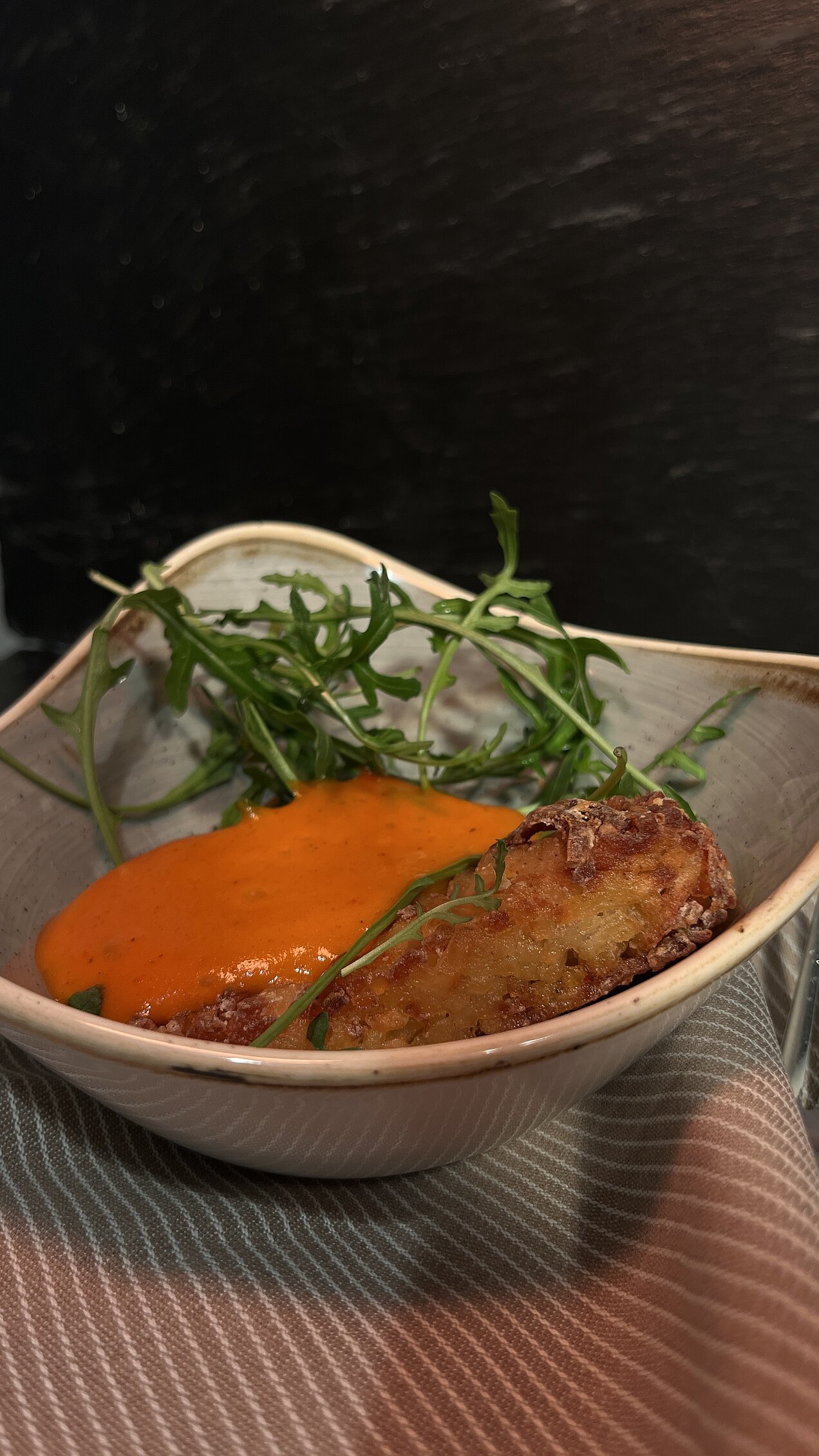 Sous-vide gegarte Wildschwein-Currywurst mit Tomaten-Curry-Espuma, eingelegter roter Zwiebel und Pommes Pailles, serviert beim Genussabend Craft & Comfort.