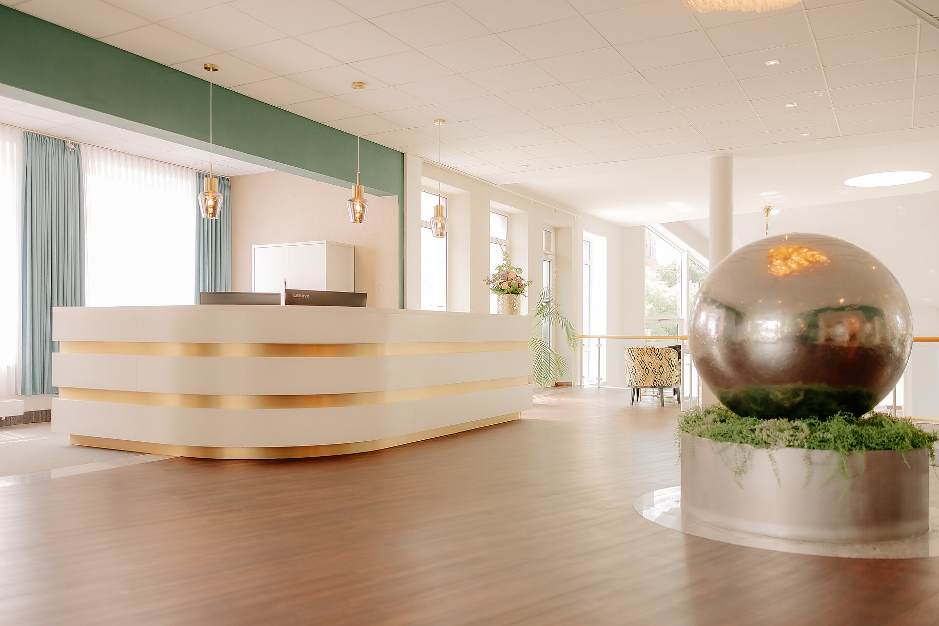 Helle Rezeption mit goldenen Akzenten in der Lobby des CASCADA Hotels Rheine