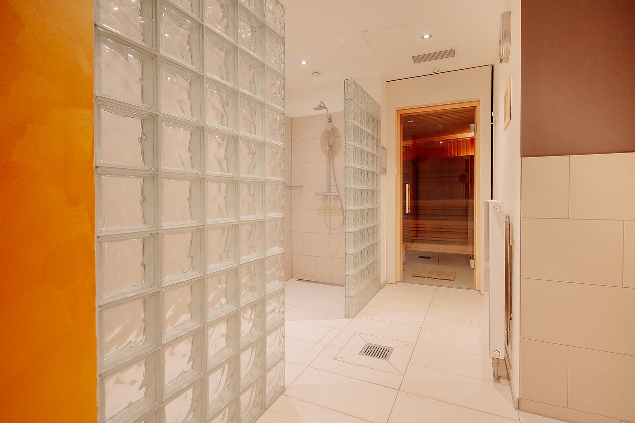 Sauna im CrossINN Osnabrück Wellnessbereich im CrossINN Osnabrück mit offenen Duschen und Blick in die Sauna