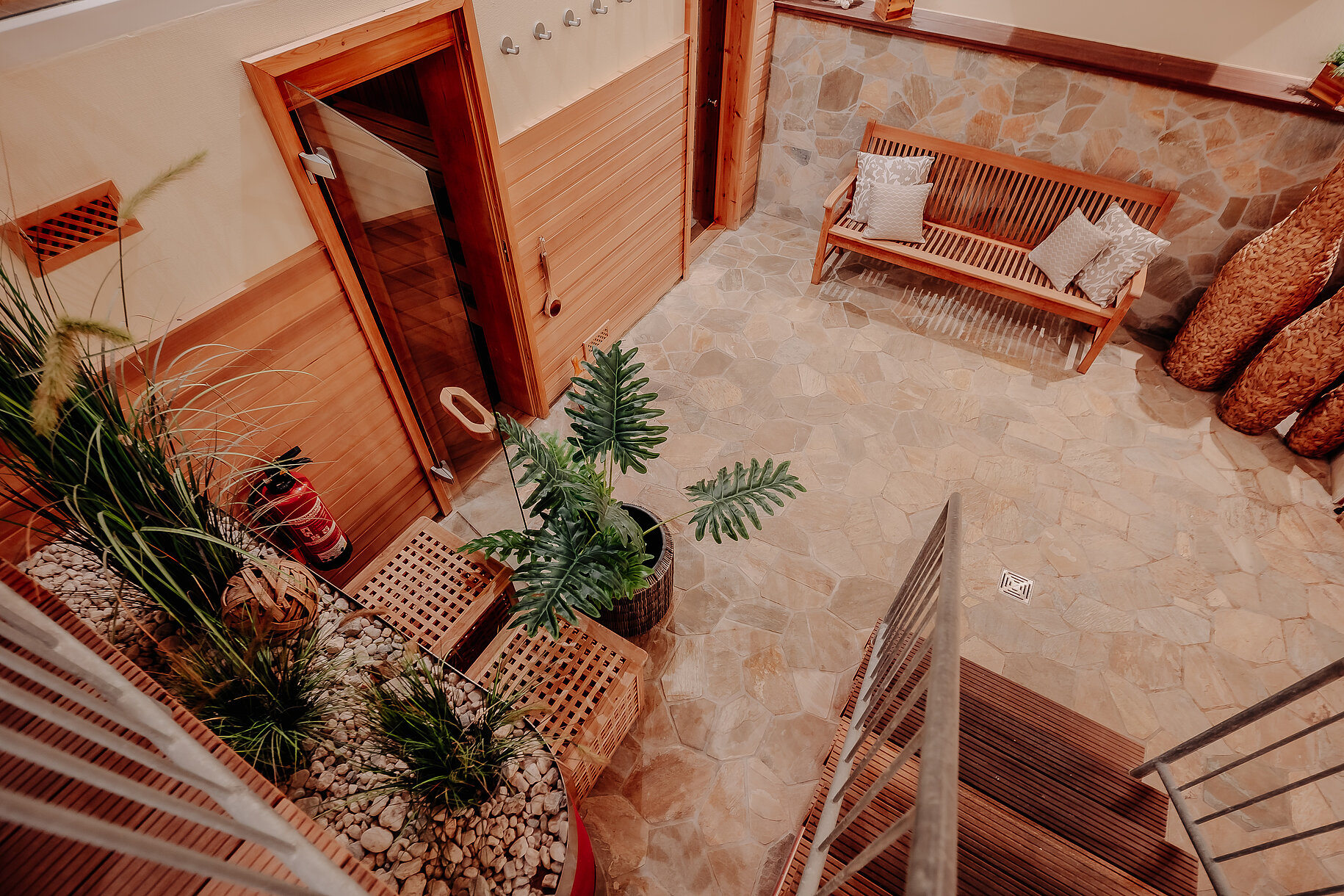  Blick von oben auf den Saunabereich im INSIDE Hotel Nordhorn mit Sitzbank und Pflanzen