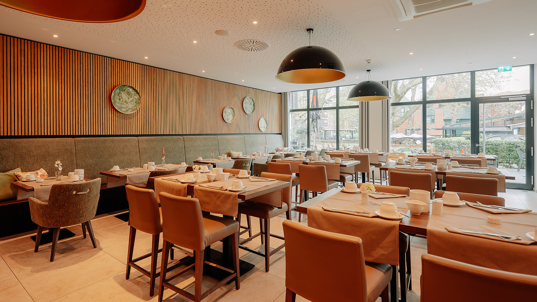 Modern eingerichteter Frühstücksraum mit großen Fensterfronten im LOOKEN INN Lingen