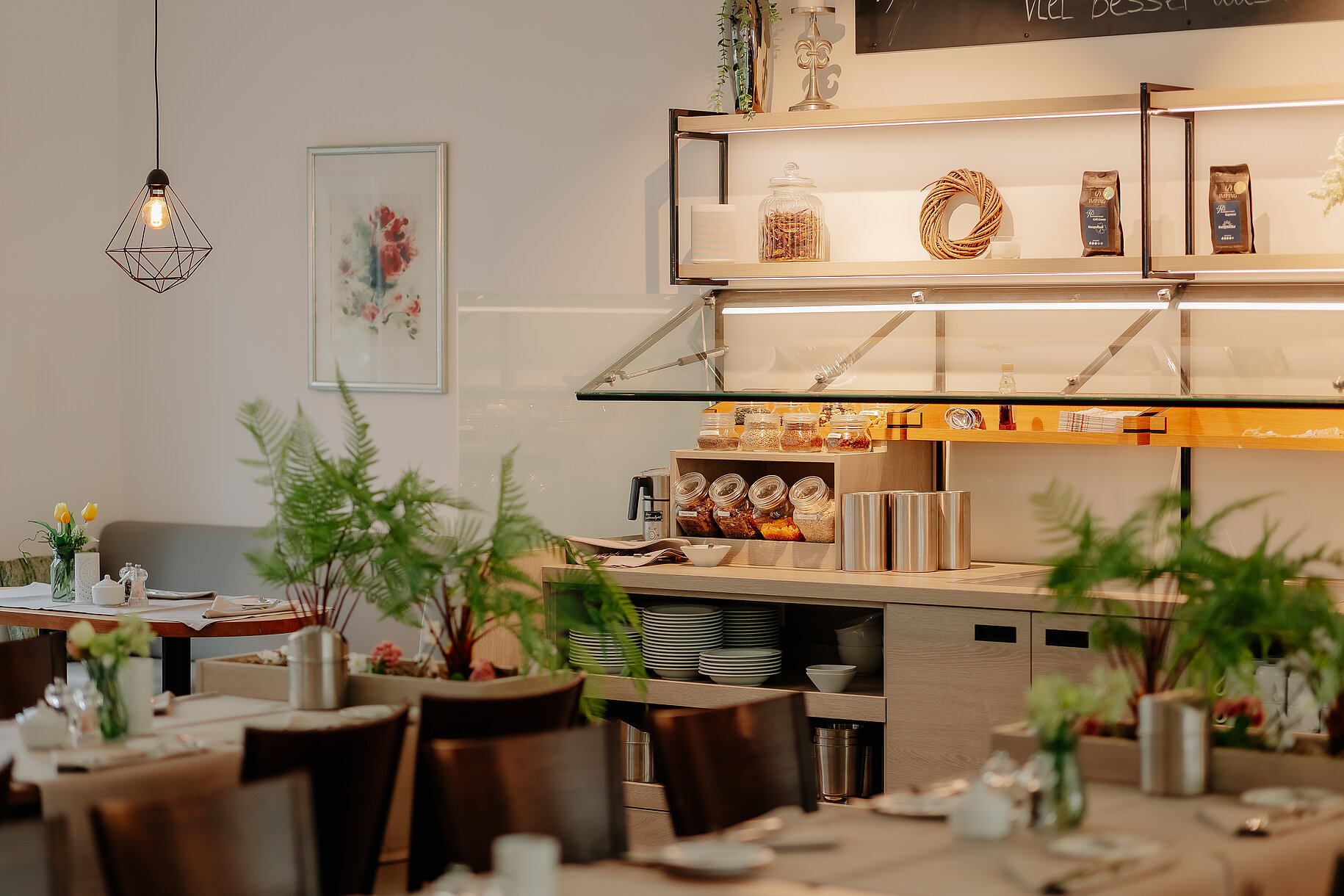 Detailaufnahme des liebevoll gestalteten Frühstücksbuffets mit Müsligläsern, Aufstrichen und Pflanzen