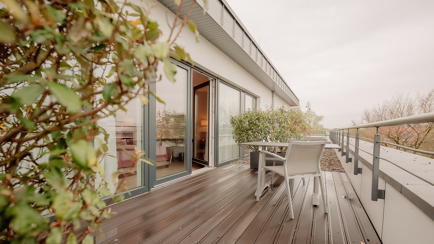 Große Dachterrasse mit Sitzgelegenheit vor einem Hotelzimmer im LOOKEN INN Lingen