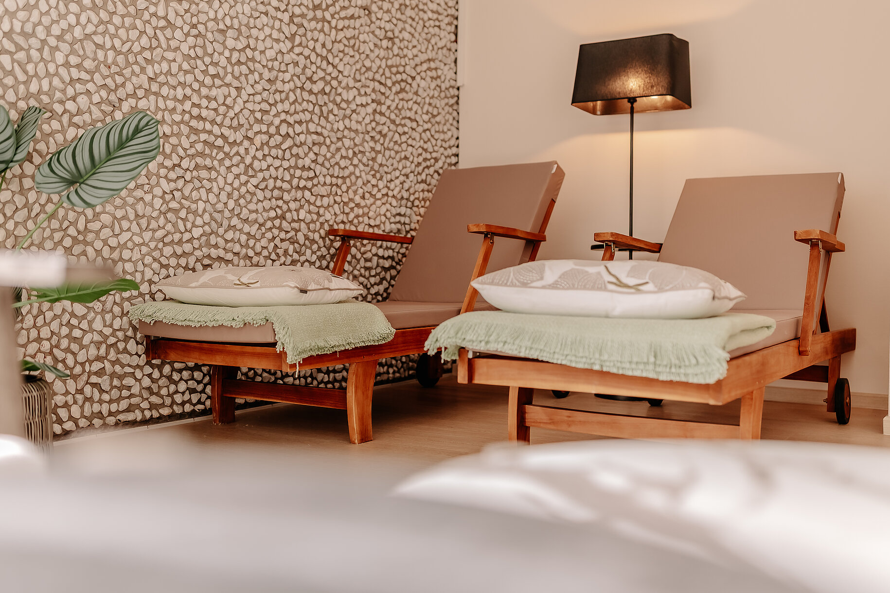 Zwei Liegen mit Kissen und Decken im Wellnessbereich des INSIDE Hotel Nordhorn