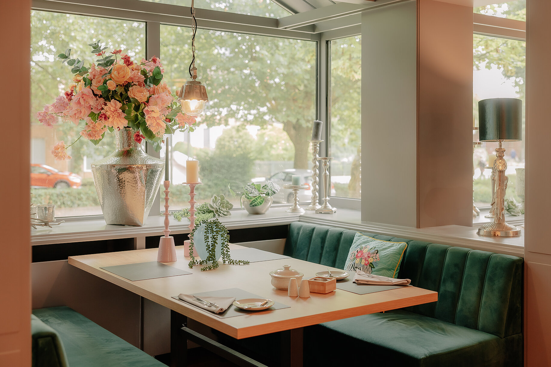 Fensterplatz im Restaurant des Stadthotels Borken mit grünem Samtpolster, Blumenarrangement und stimmiger Dekoration