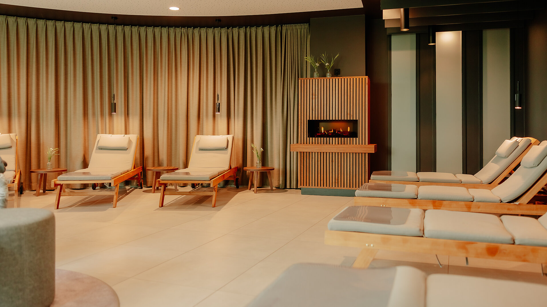 Ruheraum mit bequemen Liegen und Kamin im Hintergrund