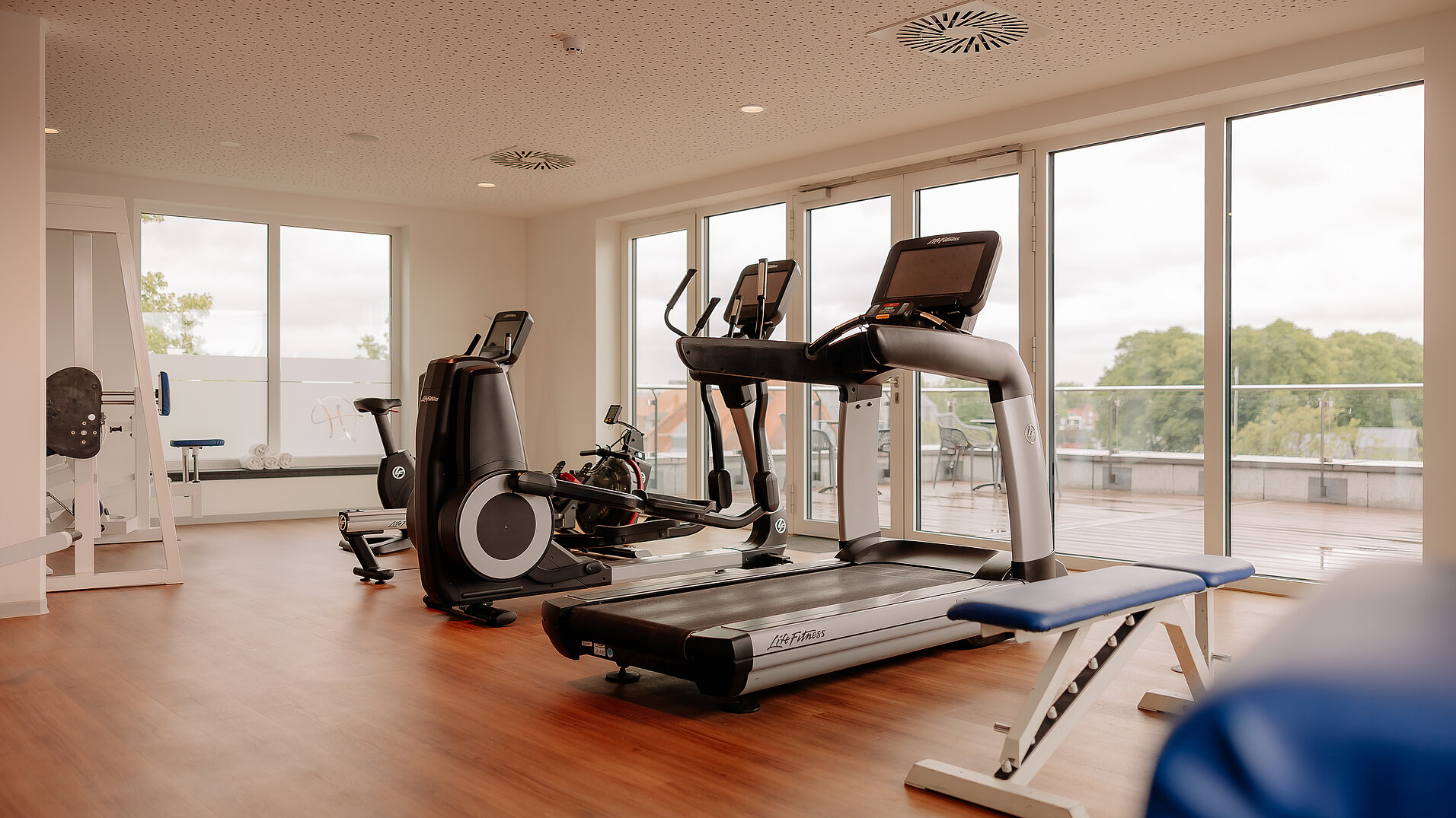 Fitnessraum mit modernen Geräten und Panoramablick