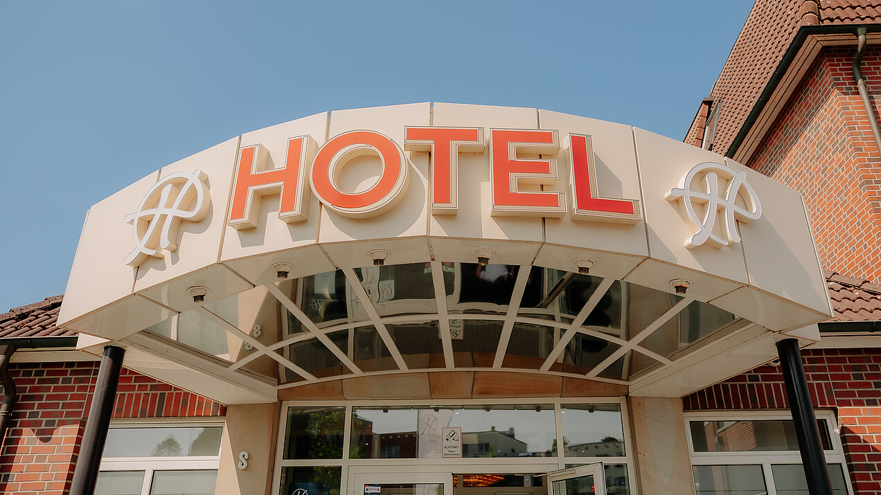 Hoteleingang des CASCADA Hotel Rheine mit leuchtenden Hackmann Hotels "H"