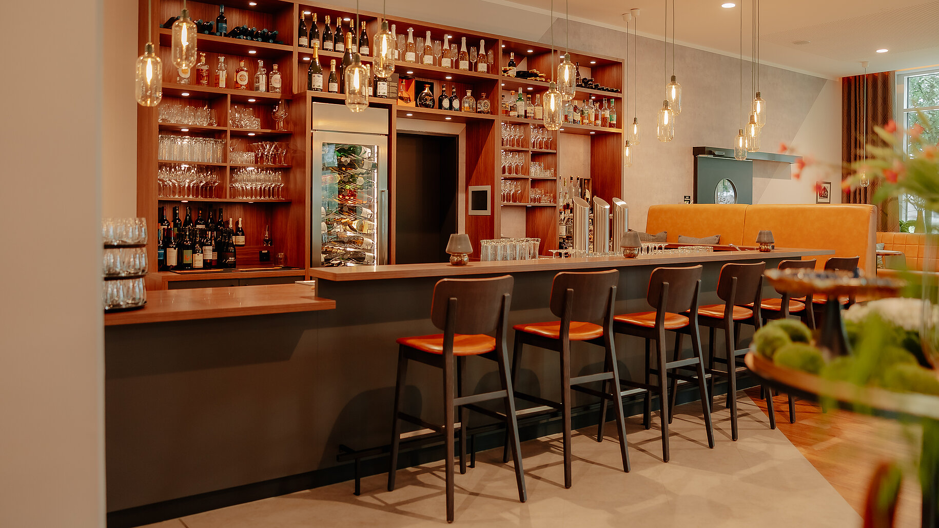 Moderne Hotelbar mit stilvoller Theke, Barhockern und gut sortiertem Getränkeangebot