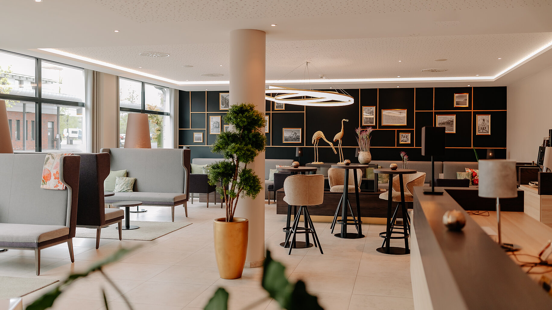 Helle, moderne Lobby mit Sitzgruppen und stilvoller Wandgestaltung im LOOKEN INN Lingen