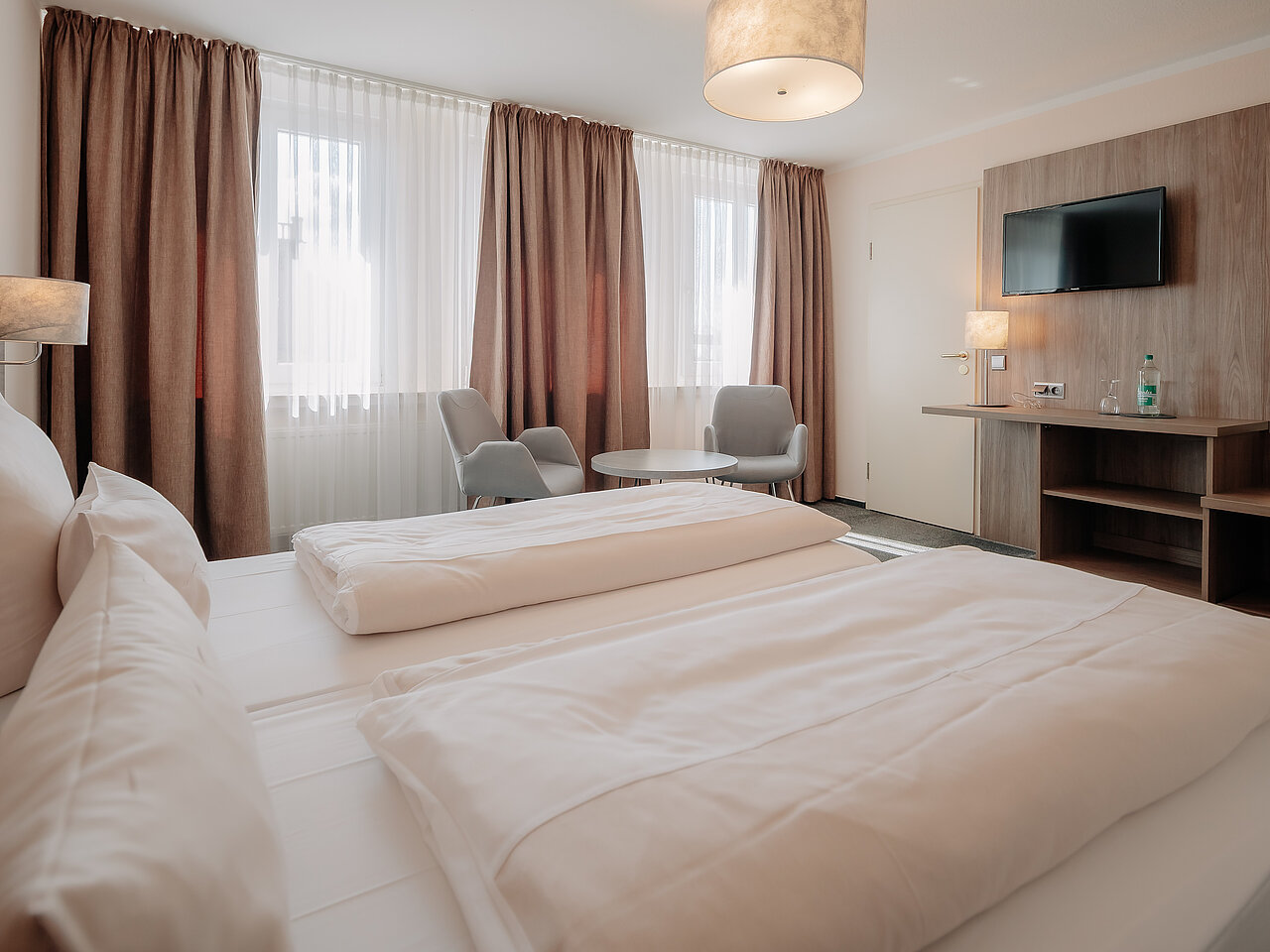 Helles Doppelzimmer mit Sitzbereich im Parkhotel Lingen