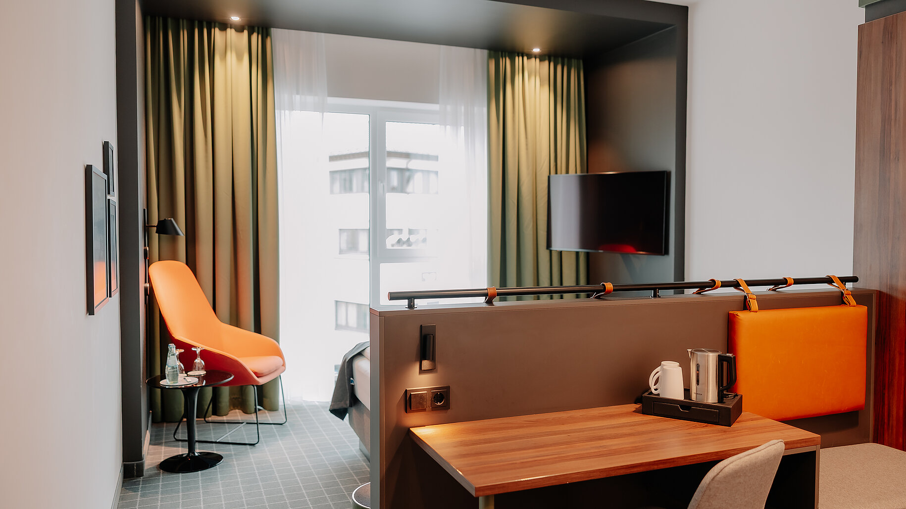 Doppelzimmer Superior im VIA PLAZA Meppen mit Schreibtisch, Lounge-Sessel und Stadtblick